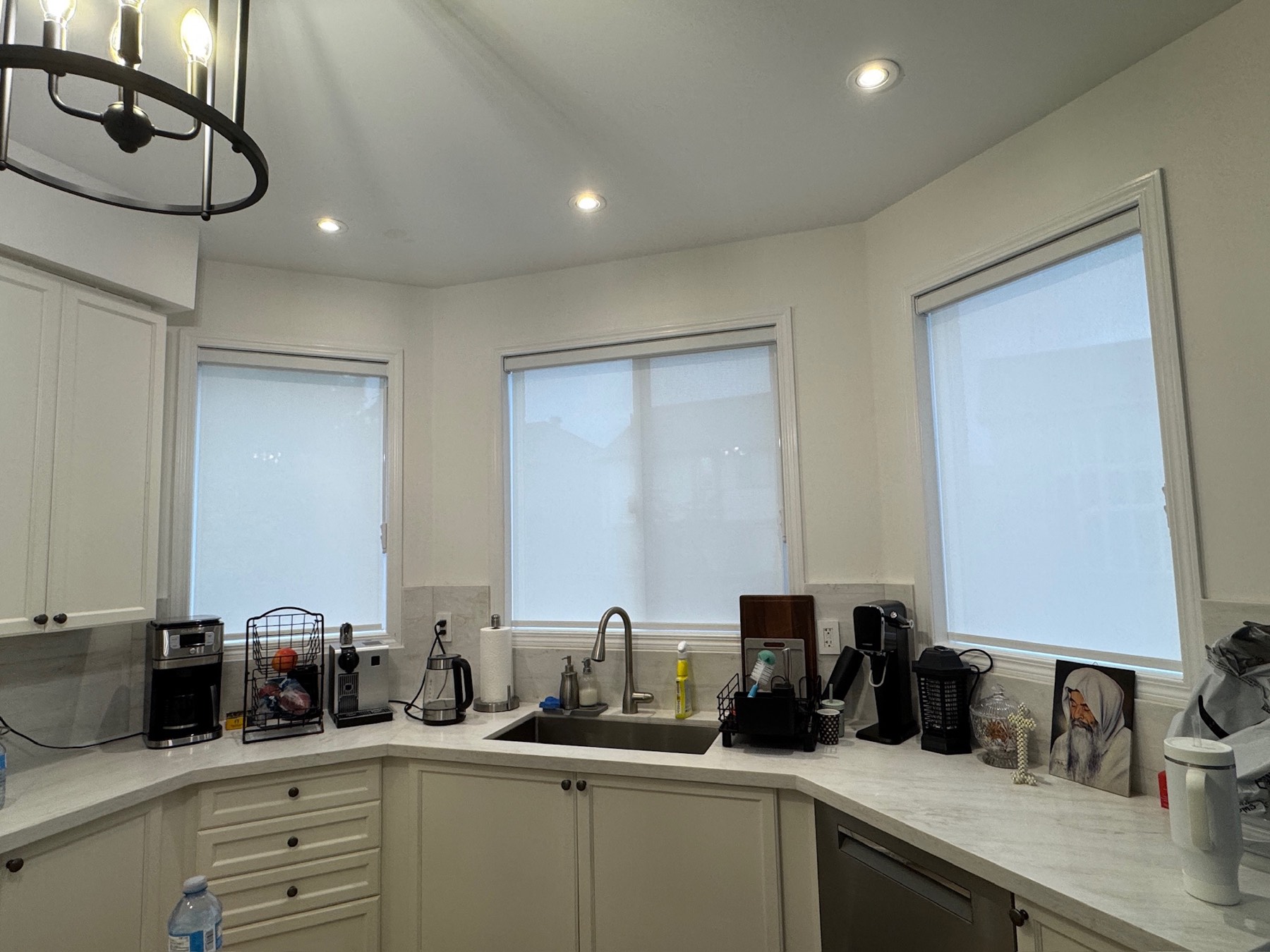 Light-filtering roller shades on three kitchen windows installed by Shadesmen